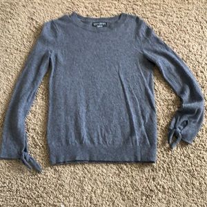 Grey sweater with tie detail at the wrist. Small